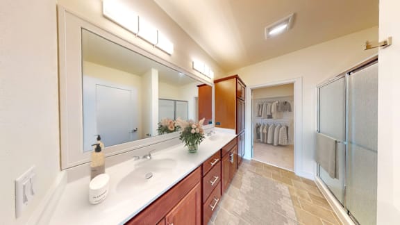 A bathroom with a vanity, mirror, and towel rack.
