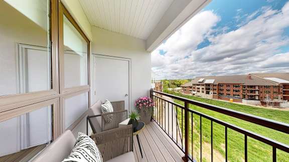 A balcony with a couch and a table with flowers on it.