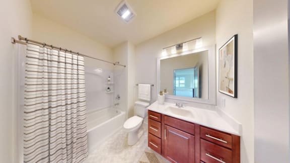 A bathroom with a toilet, sink, and shower.
