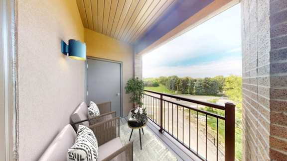 A balcony with a couch and a table with a plant on it.
