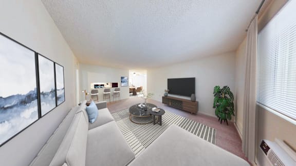 A living room with a grey couch and a large window.