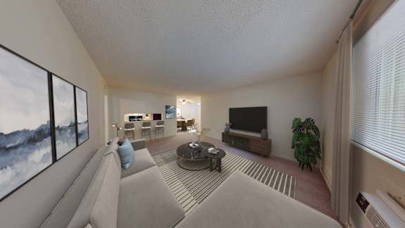 A living room with a grey couch and a large window.