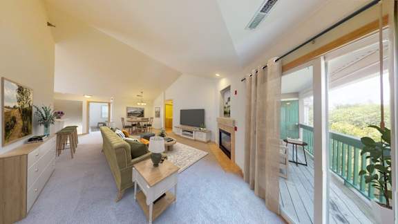 A living room with a couch, a coffee table, and a television.