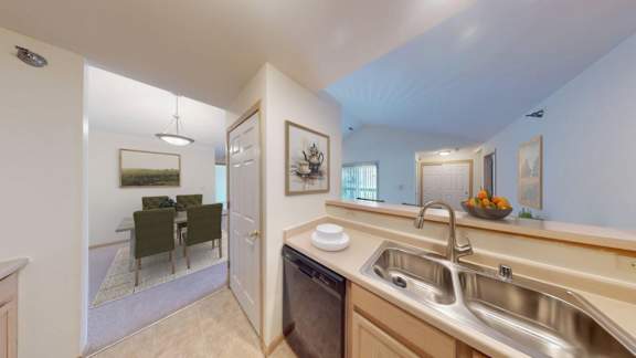 A kitchen with a dining table and chairs in the background.