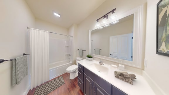 A bathroom with a toilet, sink, and mirror.