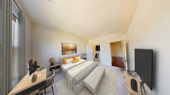 A bedroom with a bed, desk, and chair.