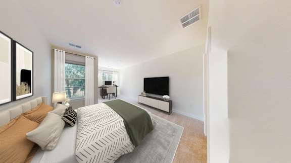 A bedroom with a bed, a couch, and a television.