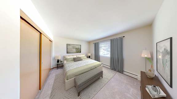 A bedroom with a large bed and a window with curtains.