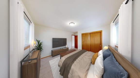 A bedroom with a bed, dresser, and window.
