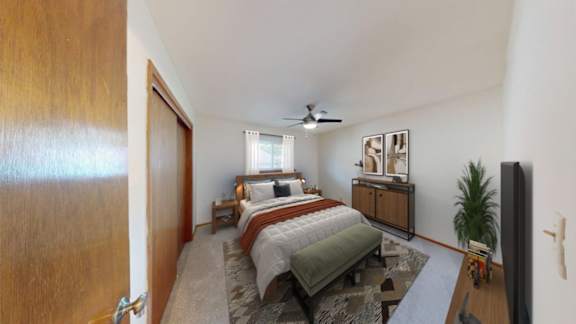 A bedroom with a bed, dresser, and ceiling fan.