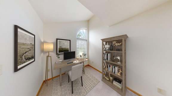 A room with a desk, chair, and bookshelf.