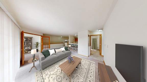 A living room with a grey couch and a wooden coffee table.