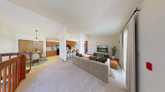 A living room with a couch, chairs, and a dining table.