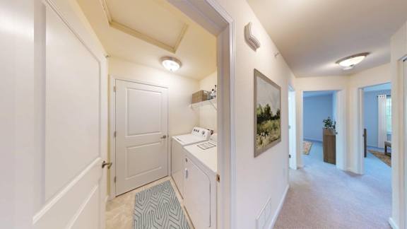 A hallway with a white door and a painting on the wall.