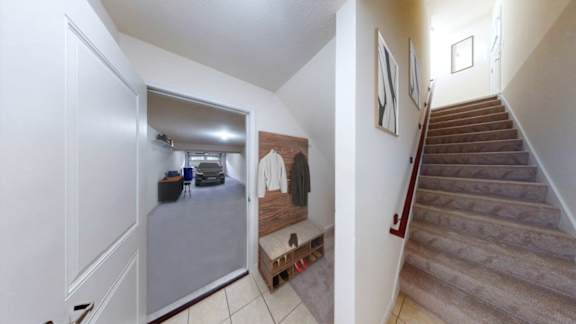A hallway with a staircase and a bench.
