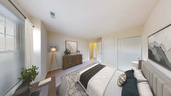 A bedroom with a bed, a laptop, a plant, and a painting on the wall.