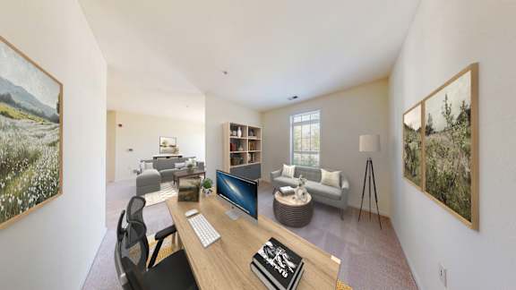 A room with a desk, chairs, and bookshelves.