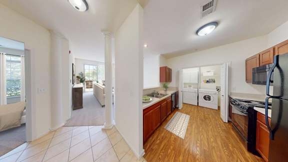 A kitchen with wooden floors and white appliances.