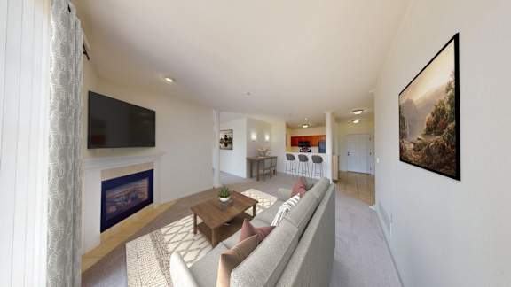 A living room with a grey couch and a painting on the wall.