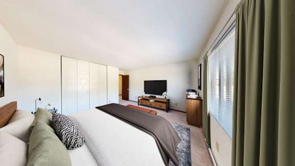 A bedroom with a large bed and a television.