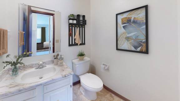 A bathroom with a marble countertop and a toilet.