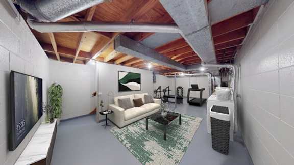 A modern living room with a white couch and a green rug.