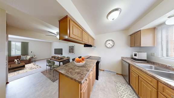 A kitchen with a brown counter top and a clock on the wall.