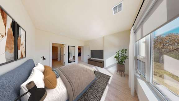 A bedroom with a large bed and a painting on the wall.