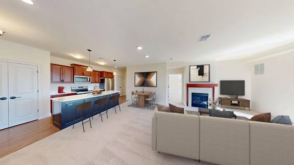 A living room with a couch, a television, and a fireplace.
