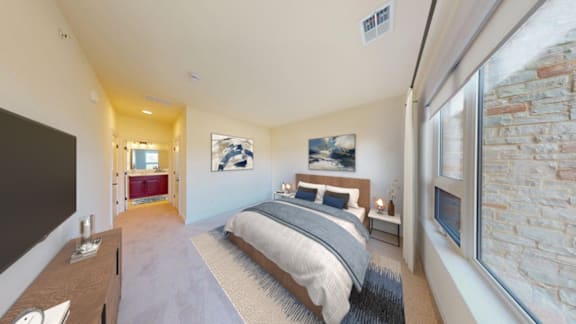 A bedroom with a large bed and a stone wall.