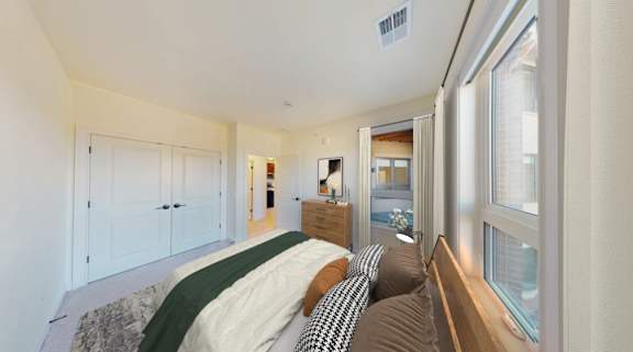 A bedroom with a bed, a window, and a dresser.