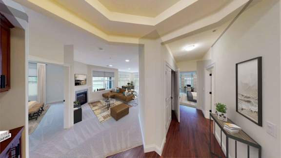 A spacious living room with a fireplace and a large painting on the wall.