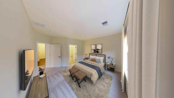 A bedroom with a bed, a bench, and a television.