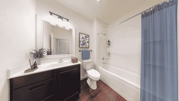 A bathroom with a toilet, sink, and shower.