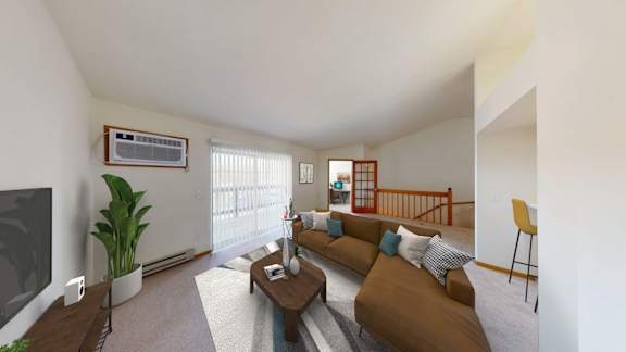 A living room with a brown couch and a television on the wall.