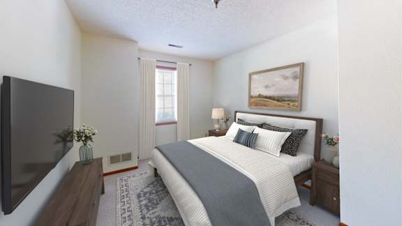 A bedroom with a large bed and a flat screen TV.