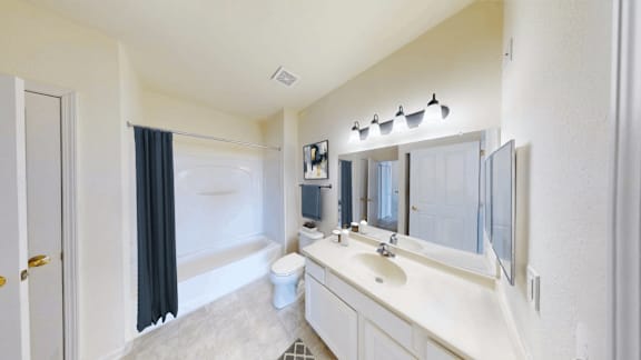 A white bathroom with a white sink and a white toilet.
