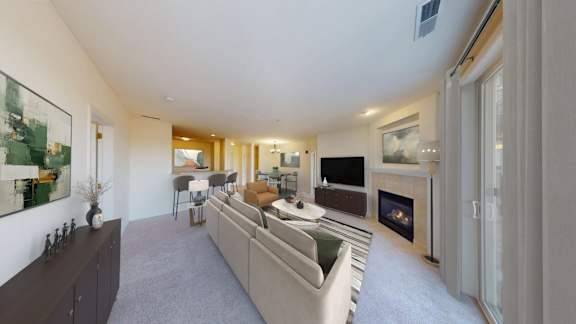 A living room with a grey couch and a fireplace.