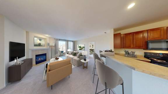 A modern living room with a fireplace and a kitchen area.