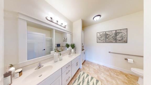 A bathroom with a white counter top and a green rug.