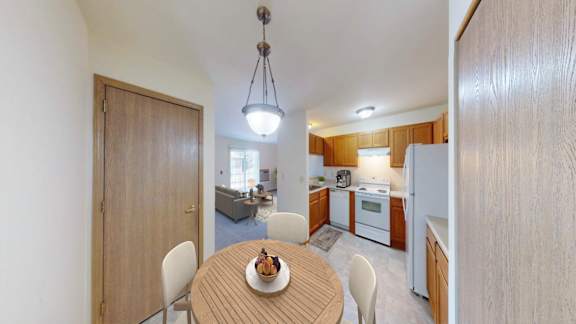 A kitchen with a table and chairs in the middle of the room.
