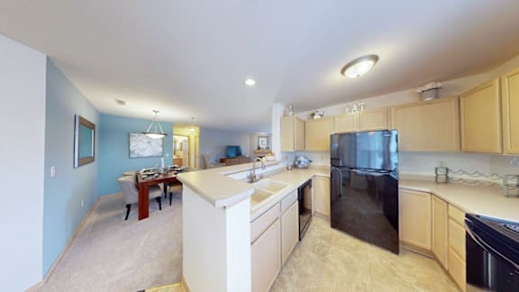 A kitchen with black appliances and wooden cabinets.