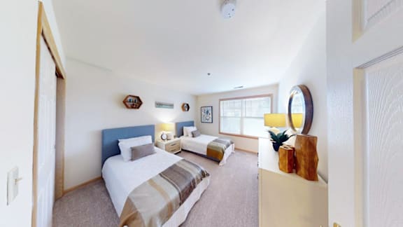 A bedroom with a bed, nightstand, and lamp.