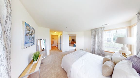 A bedroom with two beds and a nightstand.