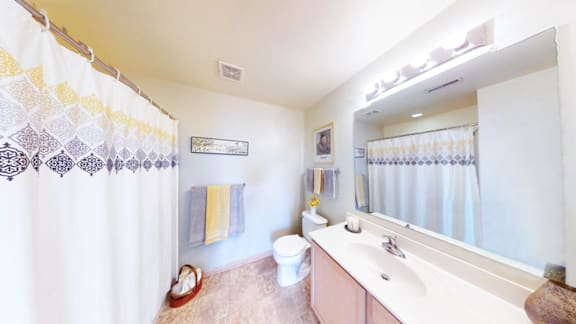 A bathroom with a white tub, toilet, and sink.