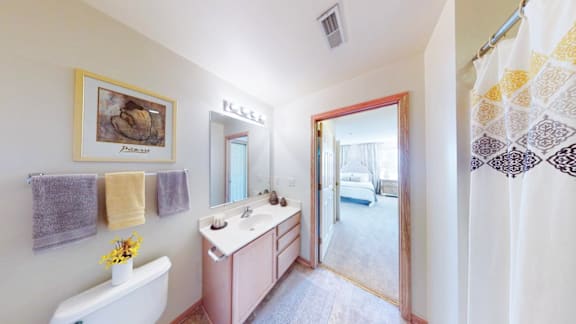 A bathroom with a white tub, sink, and towel rack.