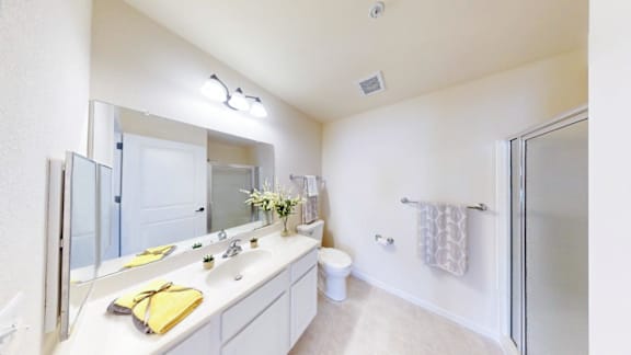 A bathroom with a white counter and a yellow towel.