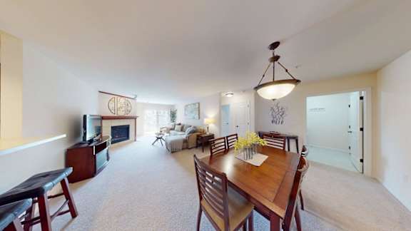 A dining room with a wooden table and chairs.