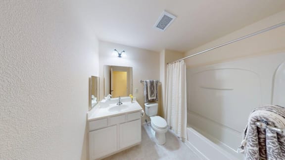 A bathroom with a toilet, sink, and shower.