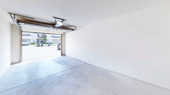 A white room with a concrete floor and a large open door.